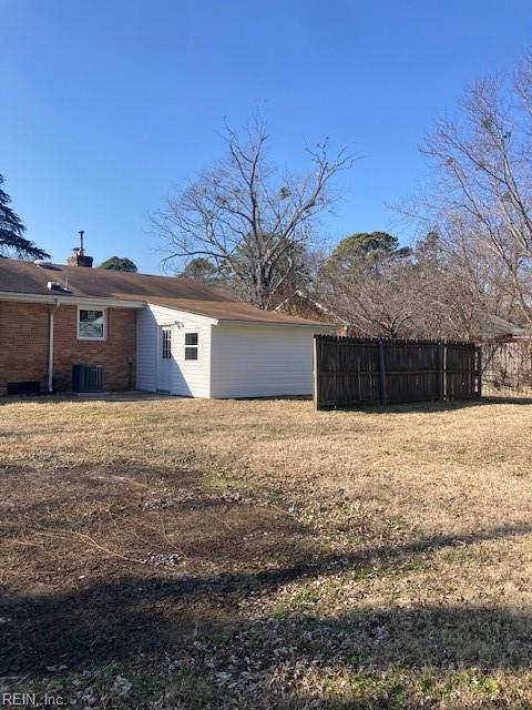 exterior space featuring central AC unit and a lawn