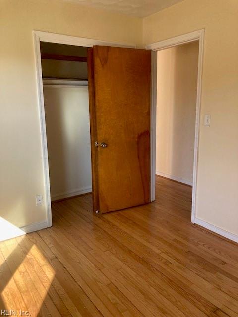 unfurnished bedroom featuring light hardwood / wood-style flooring and a closet