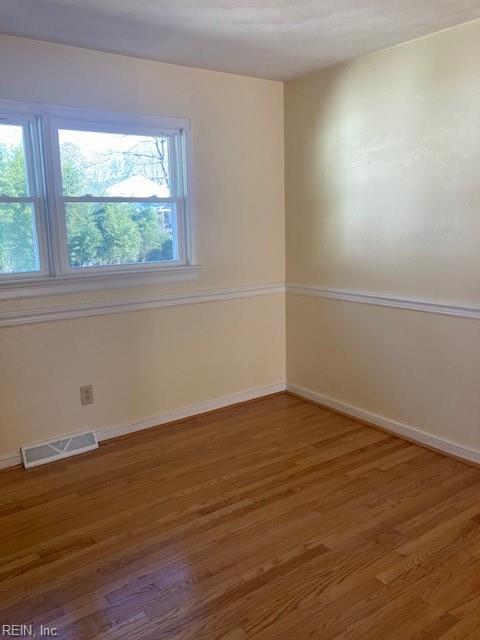 empty room with dark hardwood / wood-style flooring