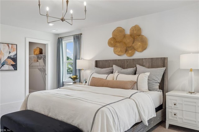 bedroom with a spacious closet, a closet, and a notable chandelier