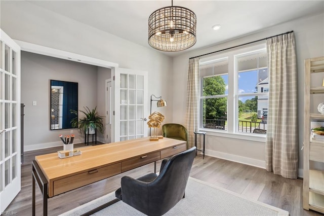 home office featuring wood-type flooring, french doors, and a chandelier