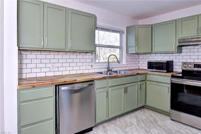 kitchen featuring sink, wooden counters, green cabinets, appliances with stainless steel finishes, and backsplash