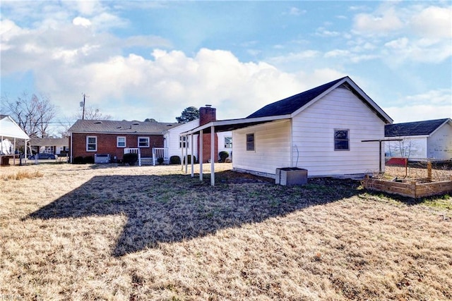 rear view of property with a lawn