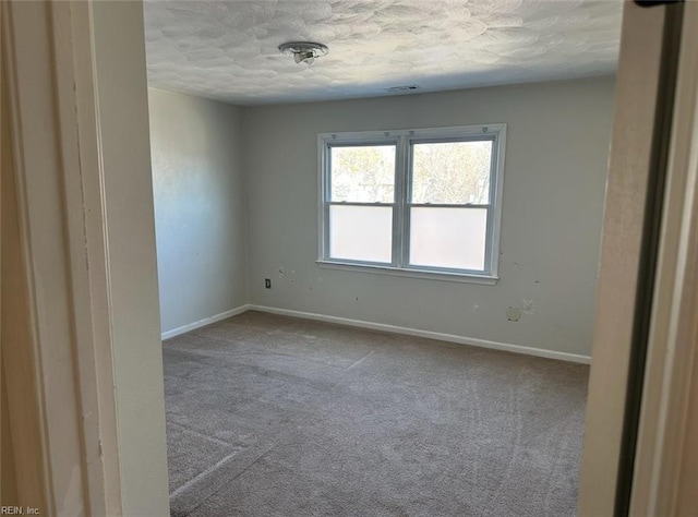 empty room featuring carpet floors and a textured ceiling