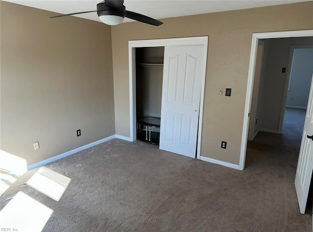 unfurnished bedroom with dark carpet, ceiling fan, and a closet