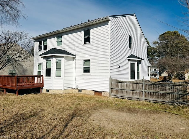 back of house with a wooden deck and a lawn