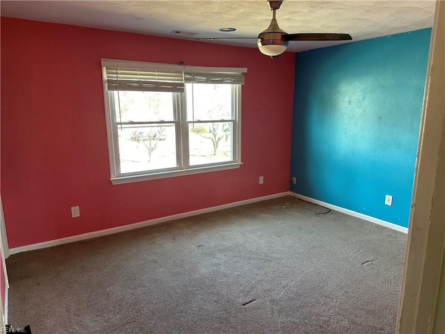 carpeted spare room featuring ceiling fan