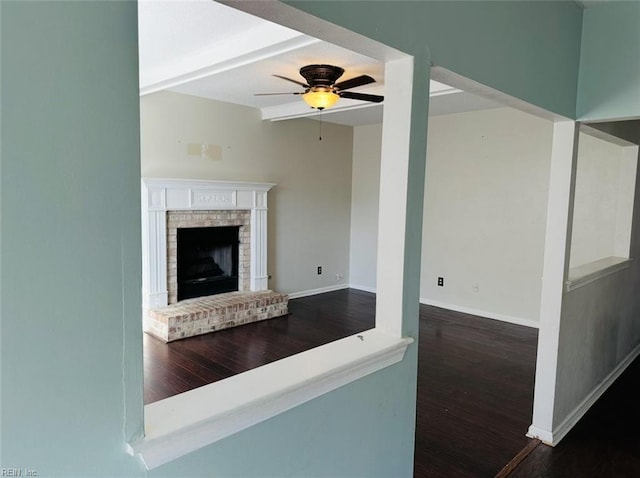 unfurnished living room featuring ceiling fan, dark wood-type flooring, and a fireplace