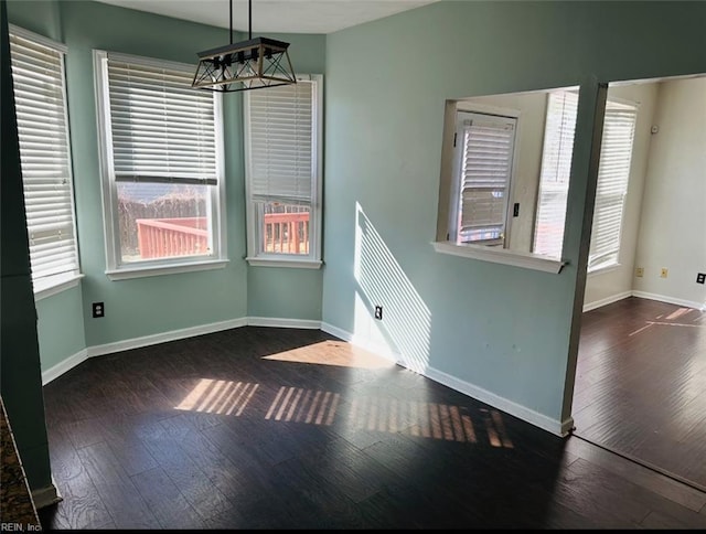 unfurnished dining area with dark wood-type flooring and a wealth of natural light