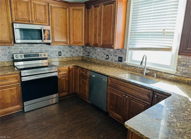 kitchen featuring stone counters, appliances with stainless steel finishes, sink, and dark hardwood / wood-style floors