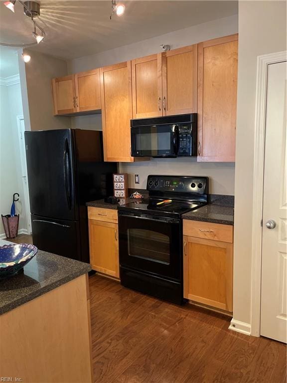 kitchen featuring dark stone countertops, dark hardwood / wood-style flooring, and black appliances