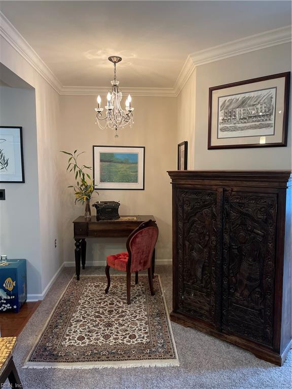 interior space with crown molding, carpet flooring, and an inviting chandelier