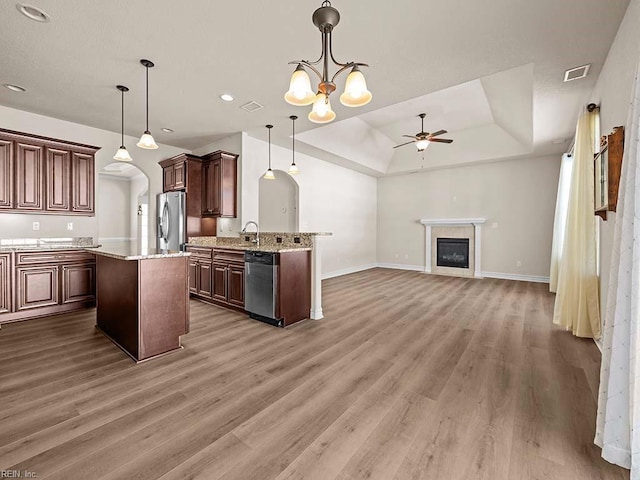 kitchen featuring pendant lighting, a tray ceiling, dark wood-type flooring, and stainless steel appliances