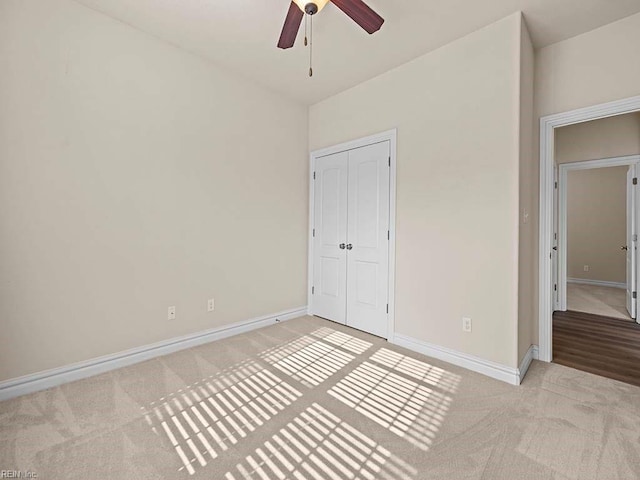 unfurnished bedroom featuring light carpet, a closet, and ceiling fan