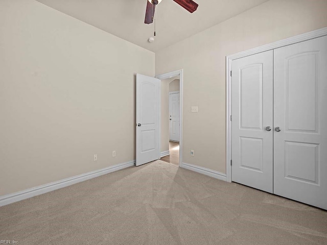 unfurnished bedroom featuring light colored carpet, ceiling fan, and a closet