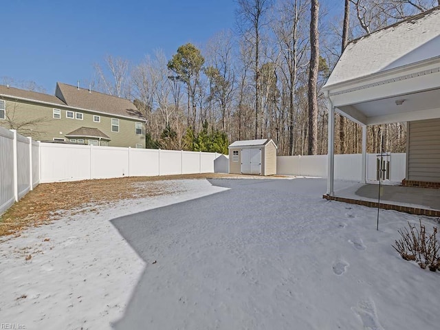 yard covered in snow featuring a storage shed