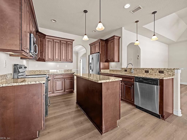 kitchen with pendant lighting, sink, light hardwood / wood-style flooring, appliances with stainless steel finishes, and a center island