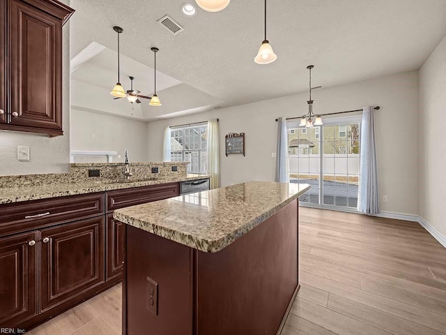 kitchen featuring a center island, plenty of natural light, sink, and decorative light fixtures