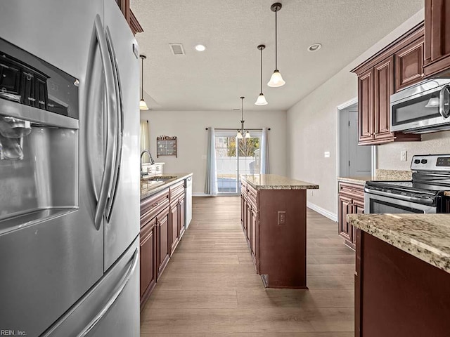 kitchen with pendant lighting, stainless steel appliances, dark wood-type flooring, and sink