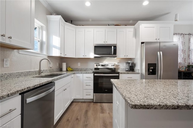 kitchen featuring stainless steel appliances, sink, and white cabinets