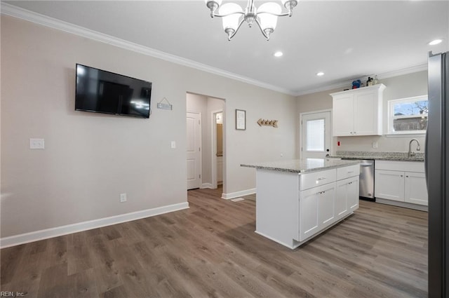 kitchen with white cabinetry, appliances with stainless steel finishes, a center island, and light stone counters