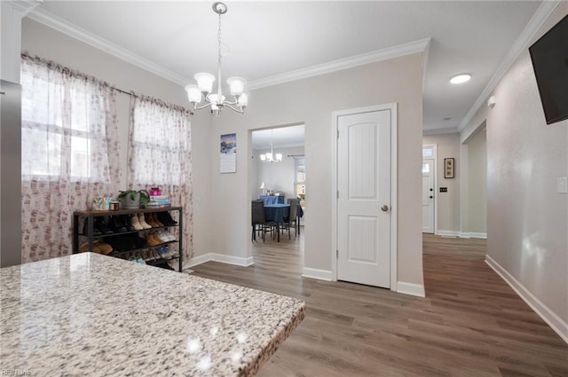 dining space featuring an inviting chandelier, dark wood-type flooring, and ornamental molding