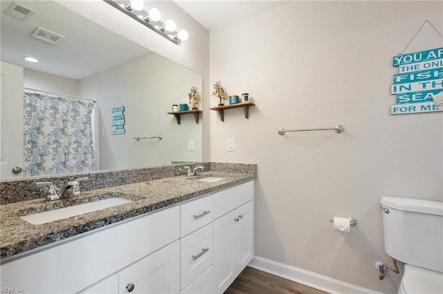 bathroom featuring vanity, wood-type flooring, a shower with shower curtain, and toilet