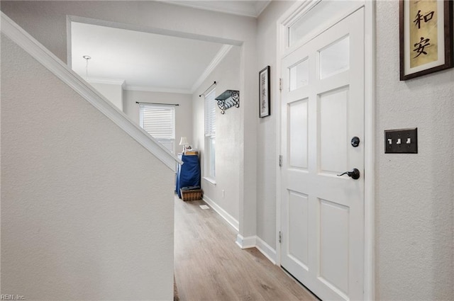 hallway with ornamental molding and light wood-type flooring