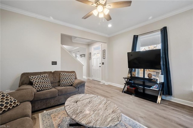 living room featuring light hardwood / wood-style flooring, ornamental molding, and ceiling fan