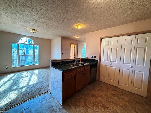 kitchen with sink, a textured ceiling, dishwasher, dark carpet, and kitchen peninsula