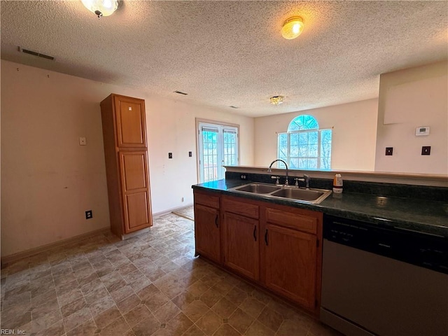 kitchen with sink, stainless steel dishwasher, and a textured ceiling