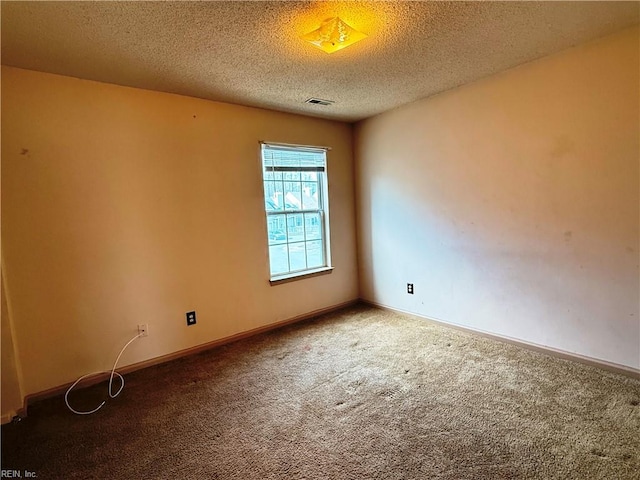 unfurnished room featuring carpet flooring and a textured ceiling