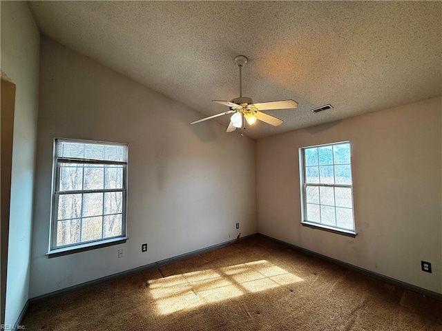 unfurnished room featuring ceiling fan, lofted ceiling, carpet floors, and a textured ceiling