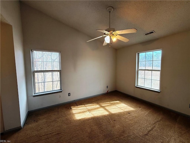 empty room with ceiling fan, carpet floors, a textured ceiling, and vaulted ceiling