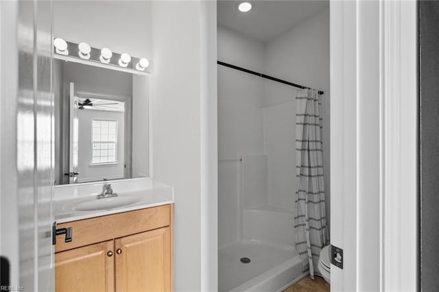 bathroom featuring walk in shower, vanity, and toilet