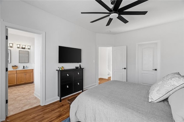 bedroom with hardwood / wood-style flooring, ceiling fan, and ensuite bath