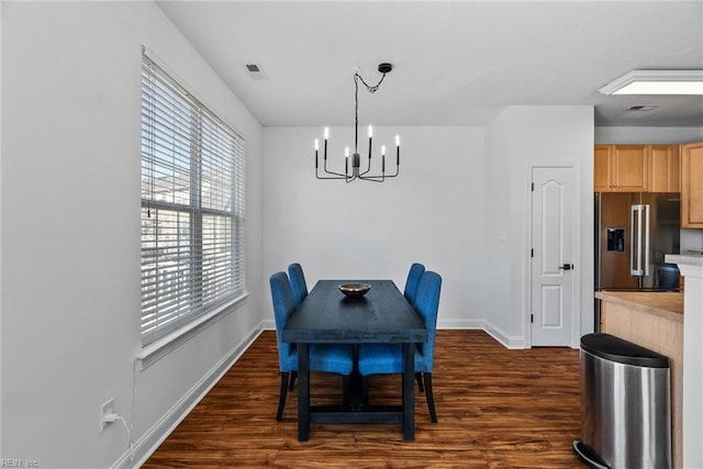 dining space featuring dark hardwood / wood-style flooring and an inviting chandelier