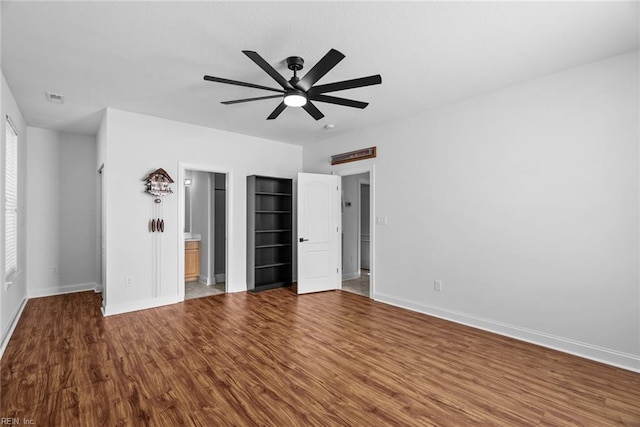 unfurnished bedroom featuring hardwood / wood-style flooring, ceiling fan, and ensuite bath