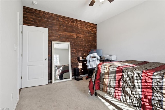 carpeted bedroom with wooden walls and ceiling fan