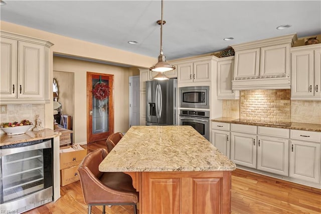 kitchen with a kitchen island, appliances with stainless steel finishes, wine cooler, decorative backsplash, and hanging light fixtures