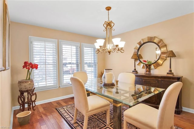 dining area featuring a healthy amount of sunlight, hardwood / wood-style floors, and a chandelier