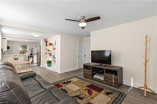 living room featuring dark wood-type flooring and ceiling fan