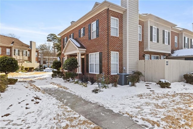 snow covered property with cooling unit