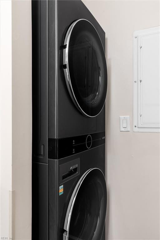 laundry room with stacked washer and dryer and electric panel