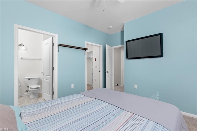 carpeted bedroom featuring ensuite bathroom, a spacious closet, and a closet