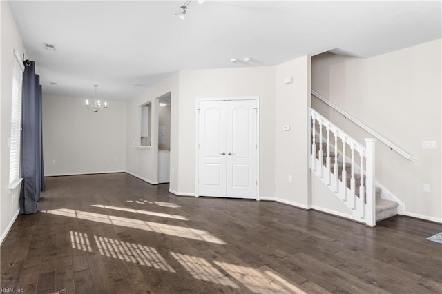 unfurnished room featuring dark hardwood / wood-style floors and a chandelier