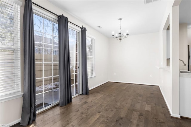 unfurnished dining area with dark hardwood / wood-style flooring, sink, and a chandelier