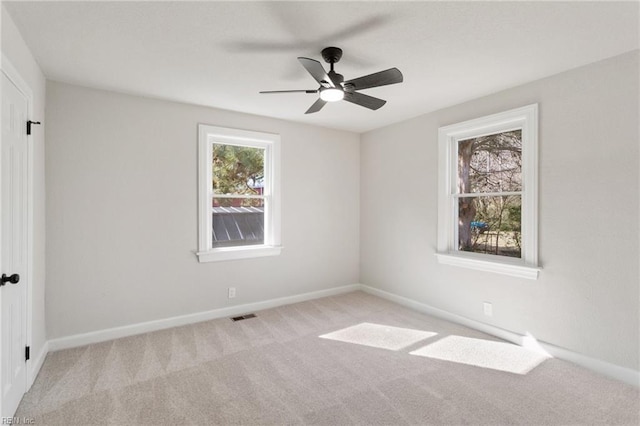 carpeted spare room featuring ceiling fan