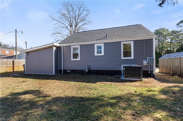 back of house with cooling unit and a lawn