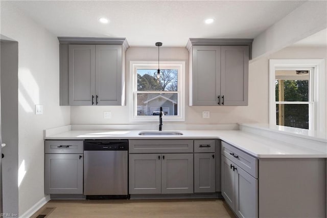 kitchen with stainless steel dishwasher, gray cabinets, sink, and hanging light fixtures